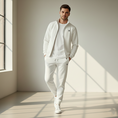 Man wearing a white tracksuit in a bright room with sunlight filtering through.