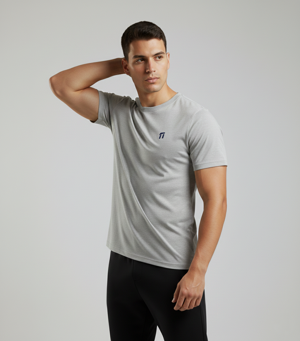 Man wearing a gray t-shirt with a logo on a plain background